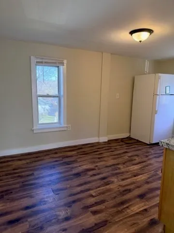 a view of a room with wooden floor and window