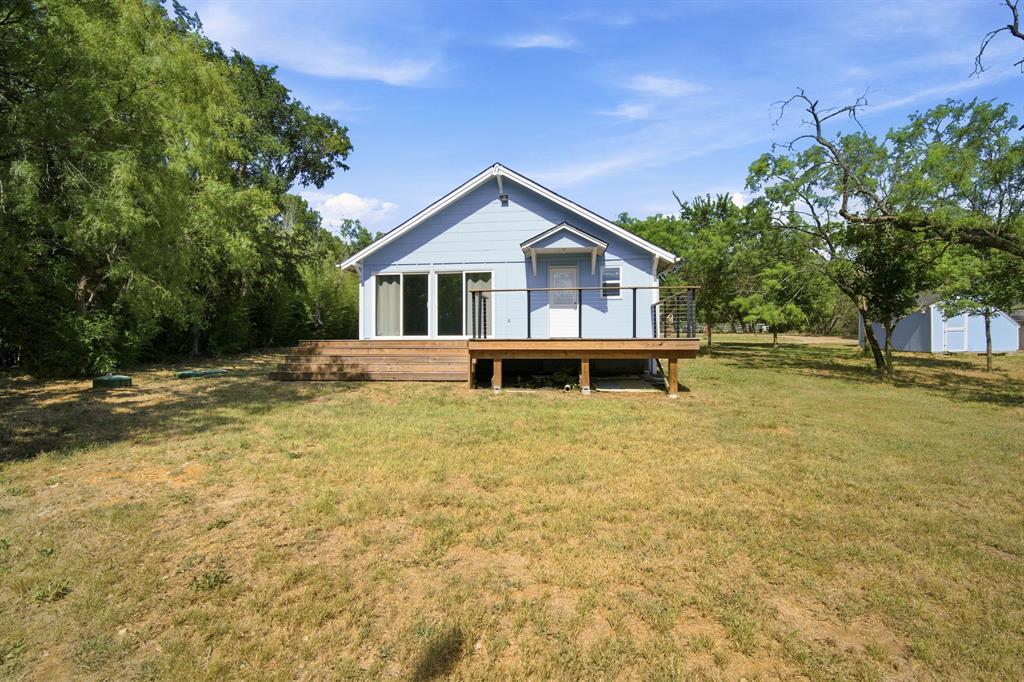 3325 Dove Creek Road Cleburne, TX 76031 - Photo 19 of 40 Light blue siding exterior featuring a multi-level wood-finish deck with modern cable railing