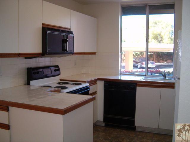 401 El Cielo Road, Unit 29 Palm Springs, CA 92262 - Photo 5 of 25 a kitchen with a sink a stove and a microwave