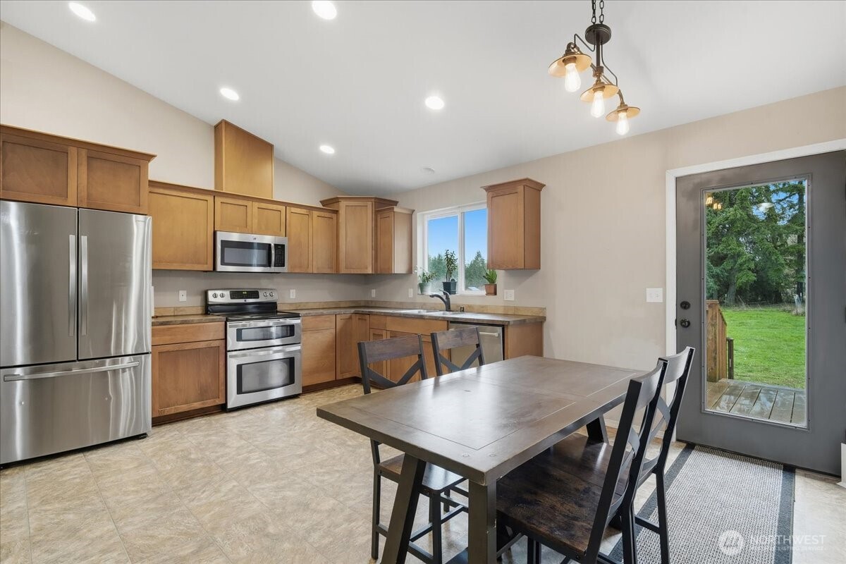 966 South Military Road Winlock, WA 98596 - Photo 5 of 31 a kitchen with refrigerator cabinets dining table and chairs