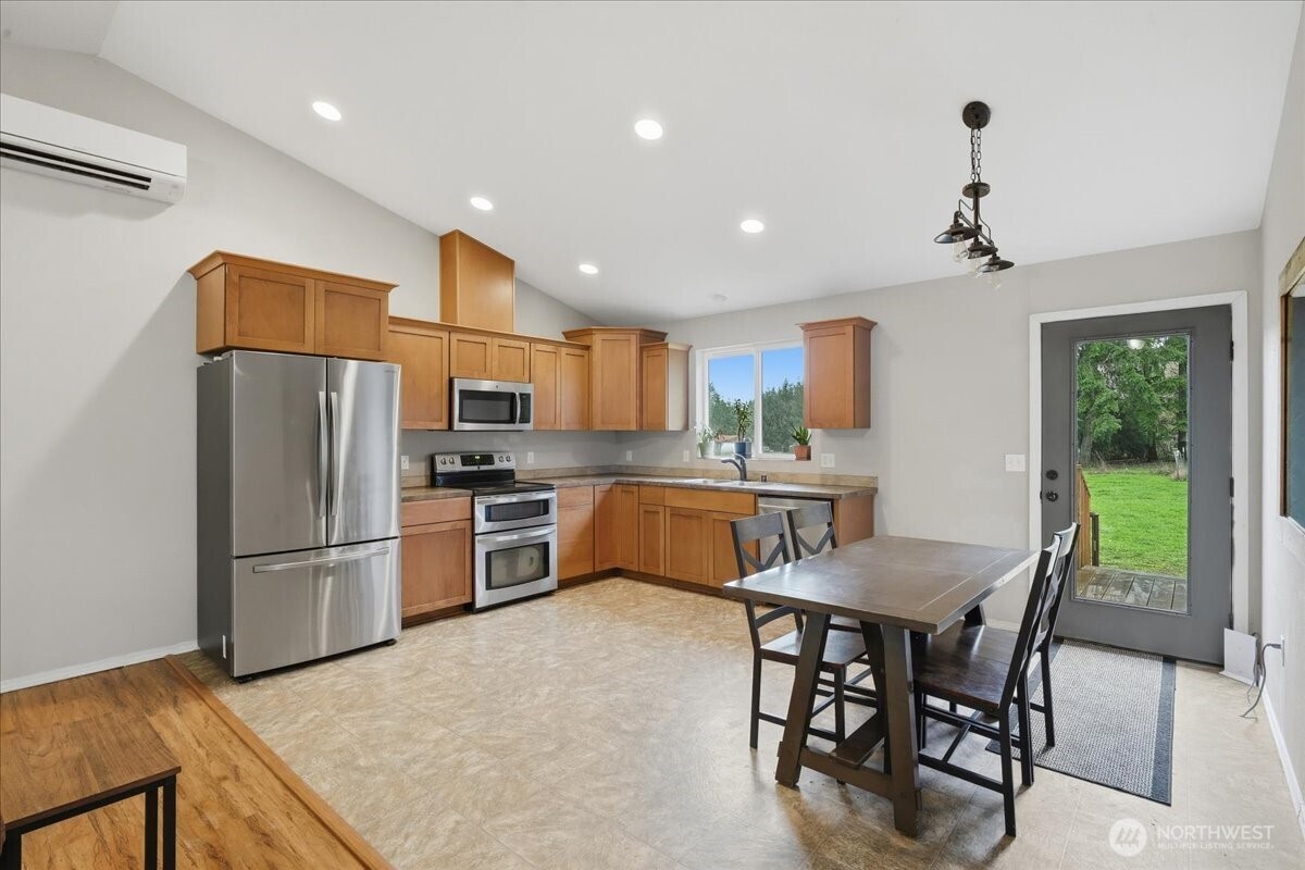 966 South Military Road Winlock, WA 98596 - Photo 6 of 31 a kitchen with stainless steel appliances granite countertop a refrigerator a sink a stove a dining table and chairs