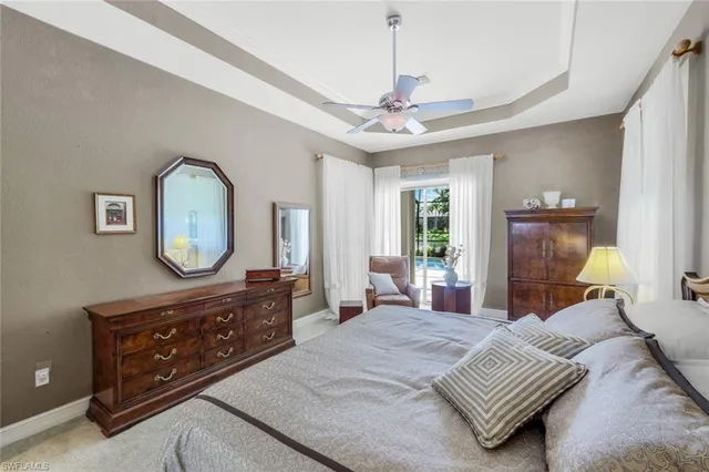 a bedroom with a bed a mirror on dresser and a chandelier
