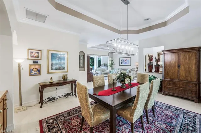a living room with furniture a dining table and a chandelier