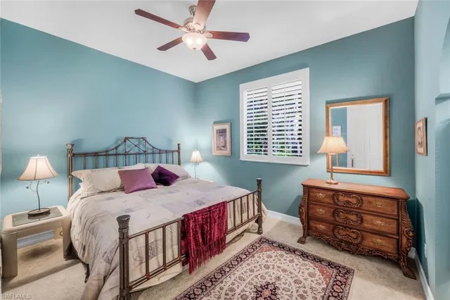 a bedroom with a bed a chandelier and a dresser