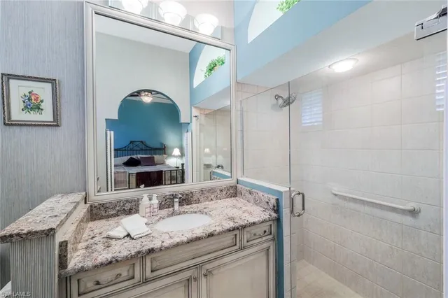 a bathroom with a granite countertop sink and a mirror