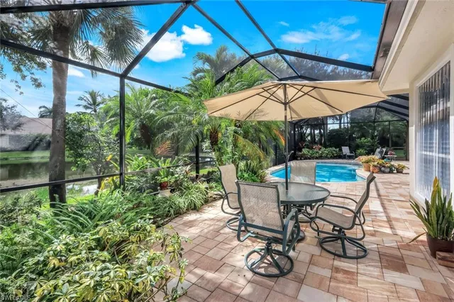 a view of patio with table and chairs under an umbrella