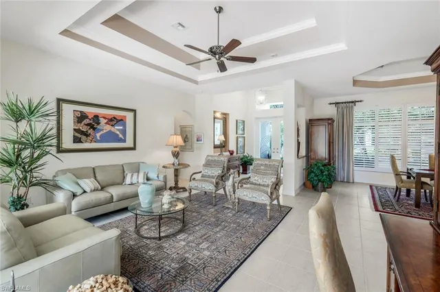 a living room with furniture a chandelier and a dining table