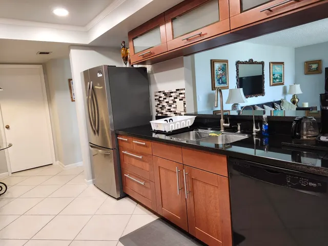 a kitchen with stainless steel appliances granite countertop a refrigerator and a sink
