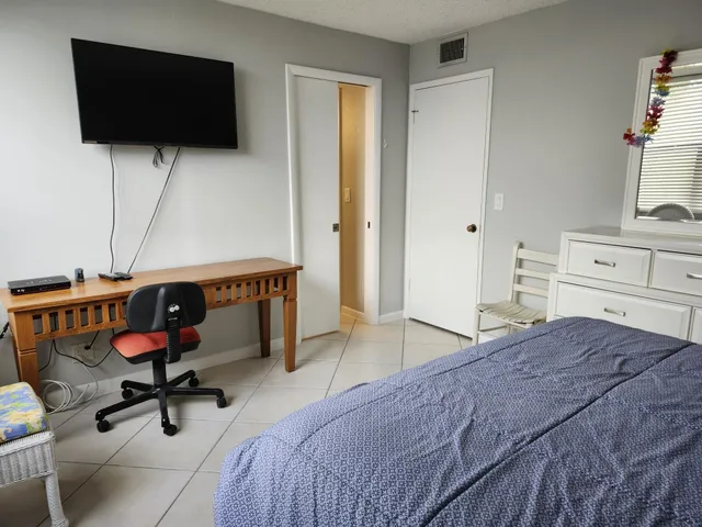 a bedroom with a bed and flat screen tv