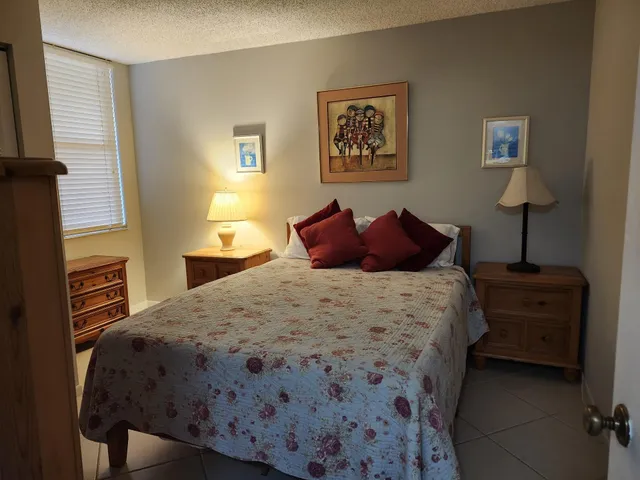 a bedroom with a bed and a lamp on dresser