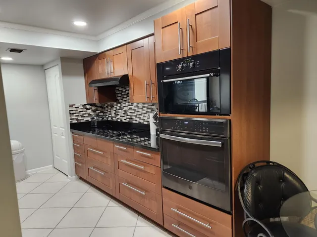 a kitchen with granite countertop white cabinets and stainless steel appliances