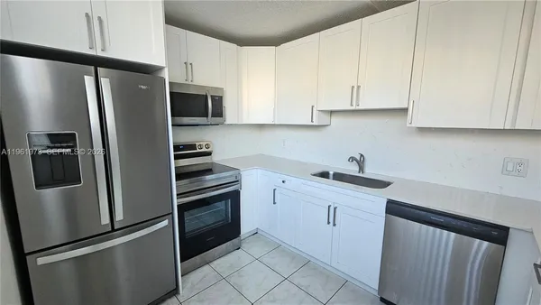 a kitchen with stainless steel appliances a refrigerator sink and microwave