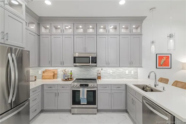 a kitchen with a sink white cabinets and stainless steel appliances