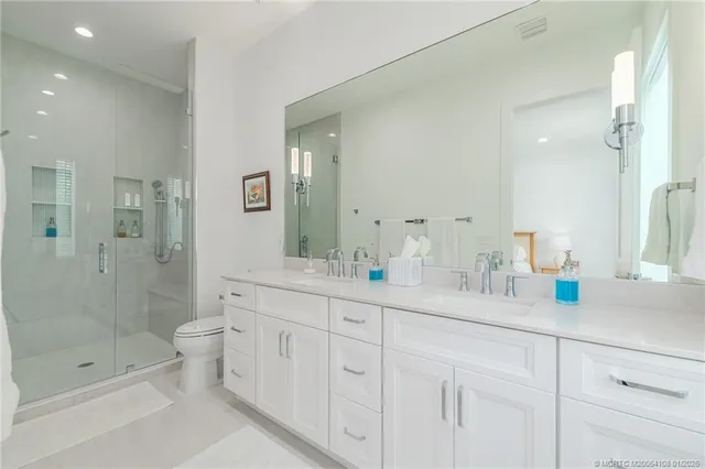 a spacious bathroom with double sink shower and a mirror