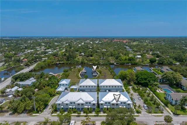 an aerial view of residential houses with outdoor space and lake view