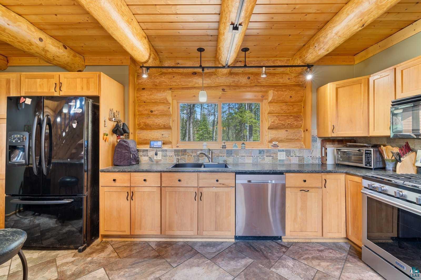 12957 West Ridge Road Ely, MN 55731 - Photo 6 of 41 Kitchen with black appliances, rustic walls, and wood ceiling