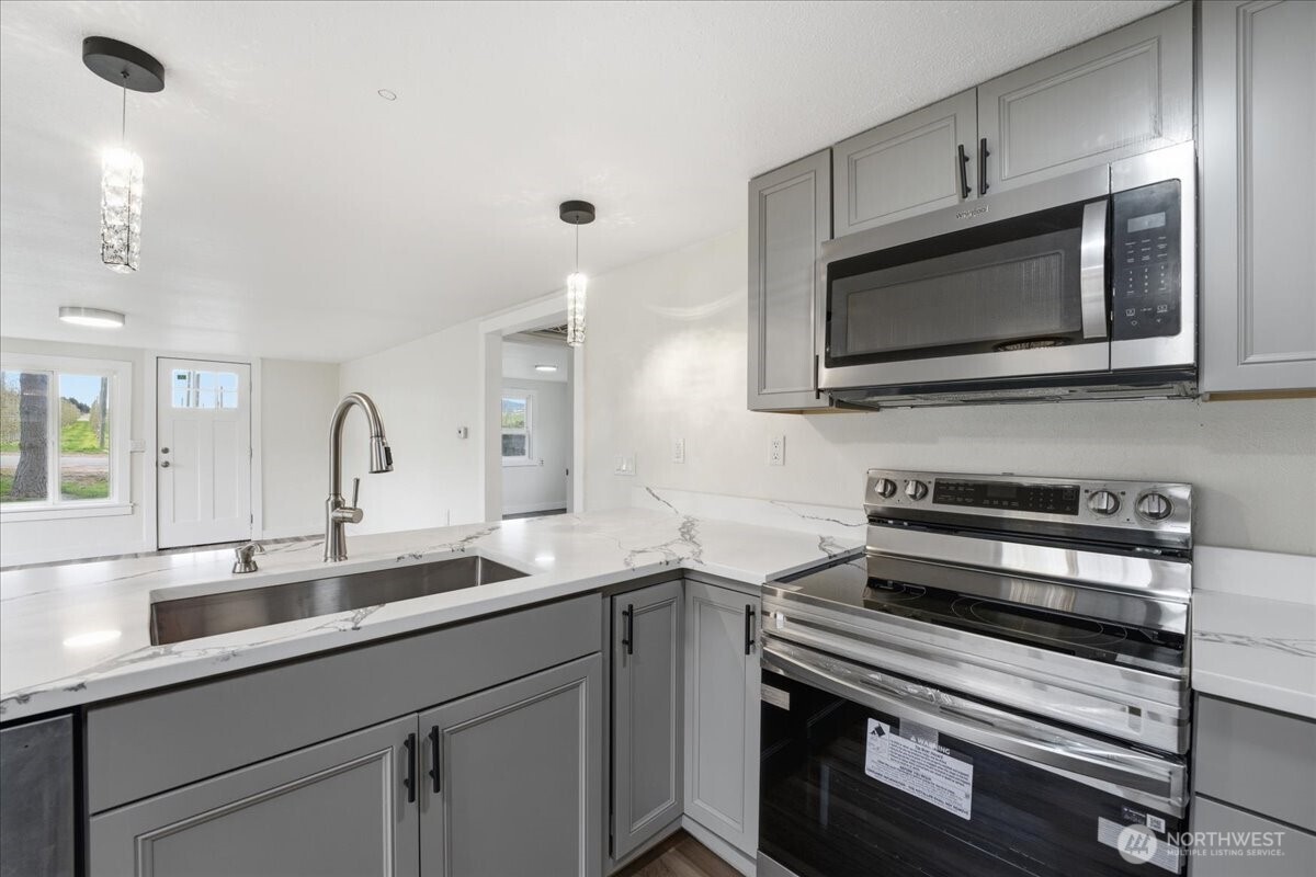 293 Barkley Road Manson, WA 98831 - Photo 12 of 40 a kitchen with a sink stove and microwave