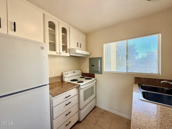 a kitchen with a stove cabinets and utility