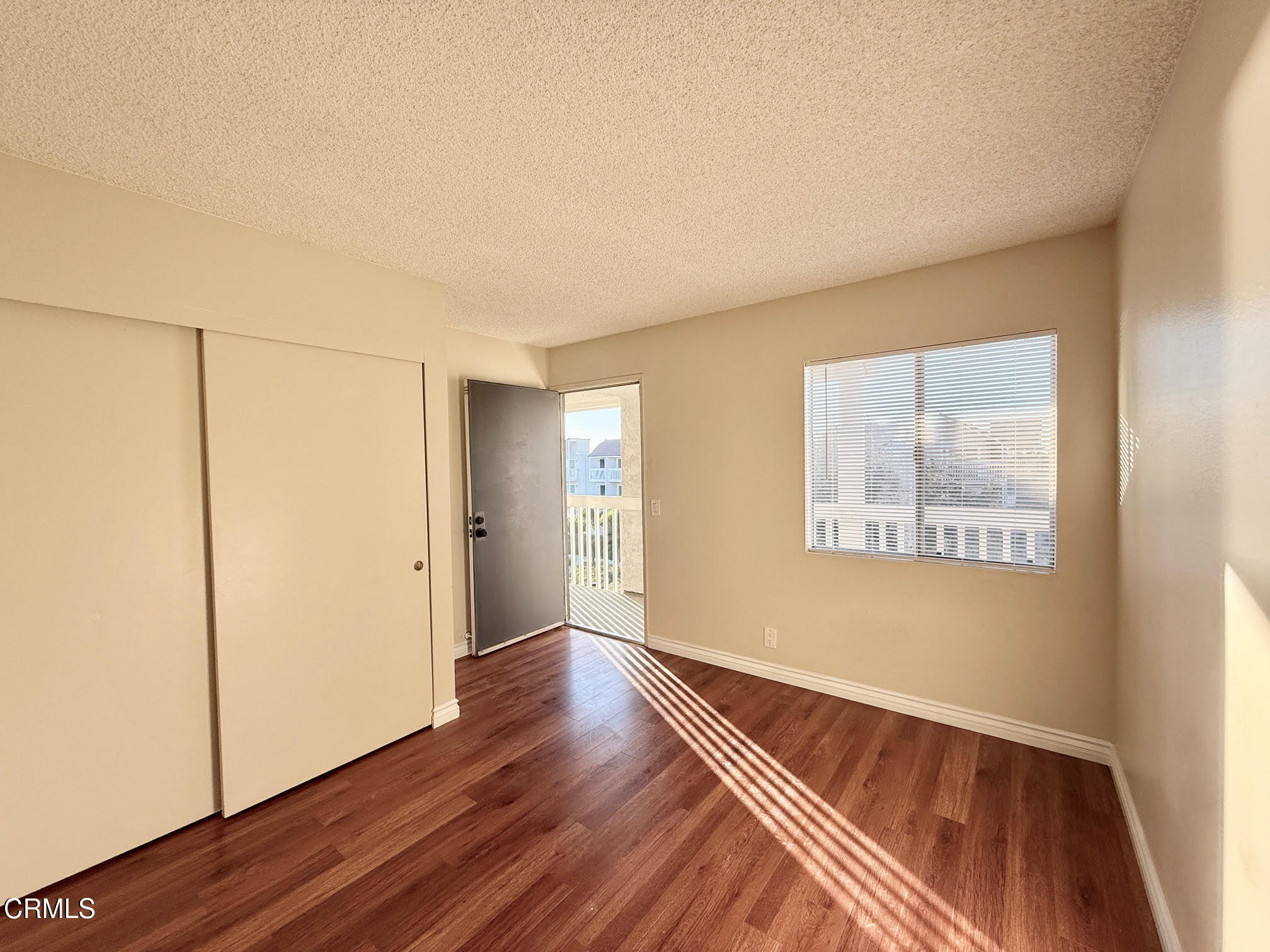 259 South Ventura Road, Unit 254 Port Hueneme, CA 93041 - Photo 25 of 30 a view of an empty room with wooden floor and a window