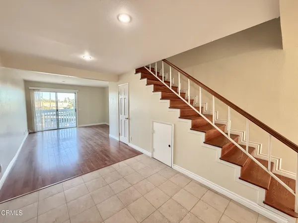 a view of staircase with wooden floor and white walls