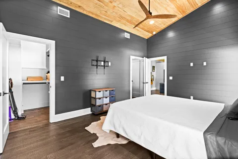 a spacious bedroom with a bed and a chandelier