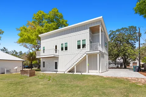 a view of a white house with a yard