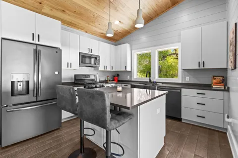 a kitchen with kitchen island a counter top space appliances and a window