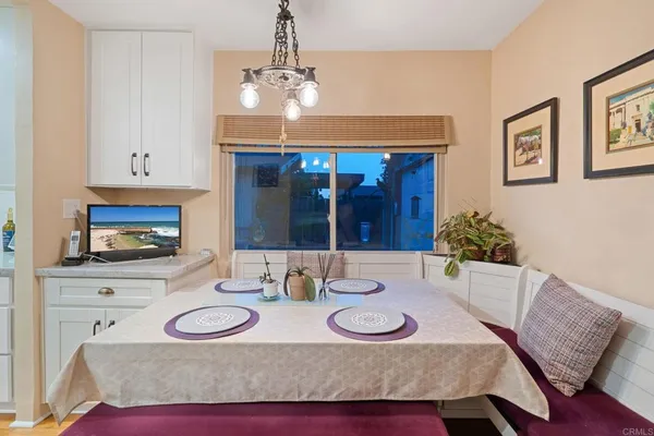 a kitchen with a dining table chairs and white cabinets