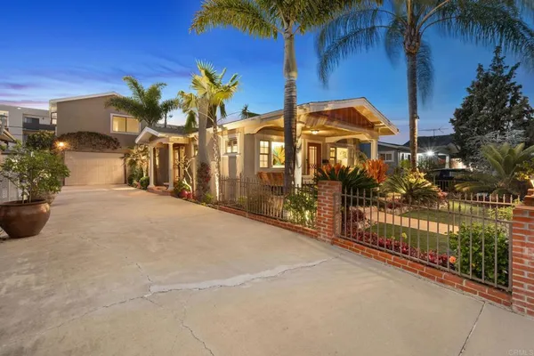 a view of a house with a yard and potted plants