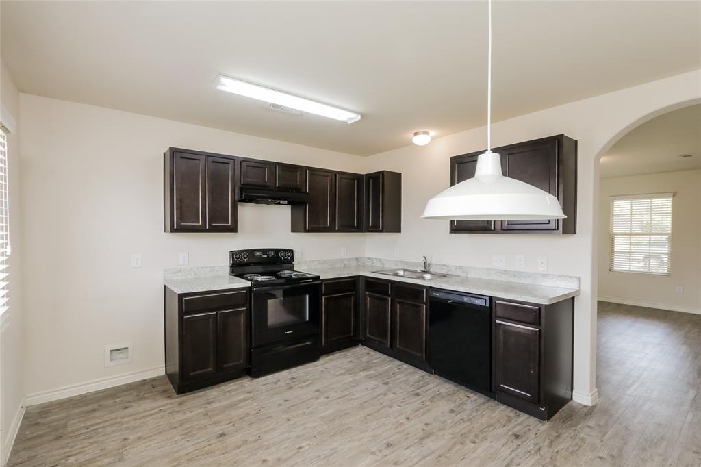 1605 Cardinal Drive Ennis, TX 75119 - Photo 3 of 16 a kitchen with stainless steel appliances granite countertop a sink stove and refrigerator