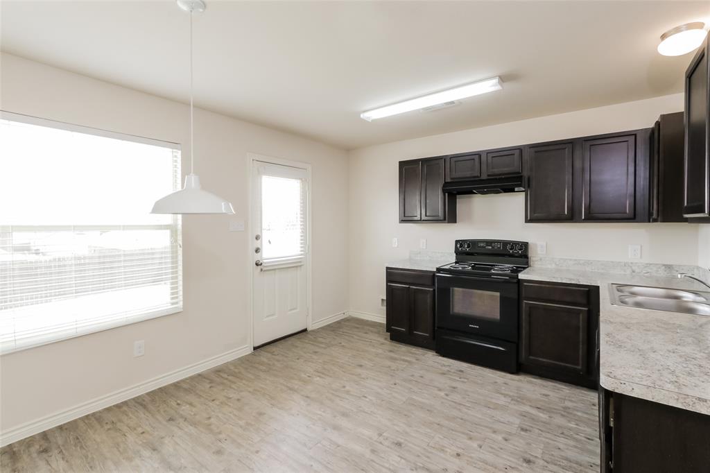 1605 Cardinal Drive Ennis, TX 75119 - Photo 4 of 16 a kitchen with granite countertop a stove top oven and sink