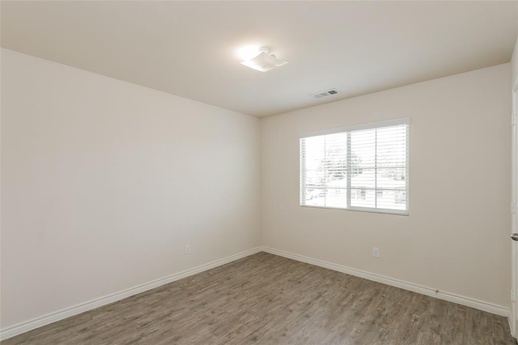 1605 Cardinal Drive Ennis, TX 75119 - Photo 8 of 16 an empty room with wooden floor and windows