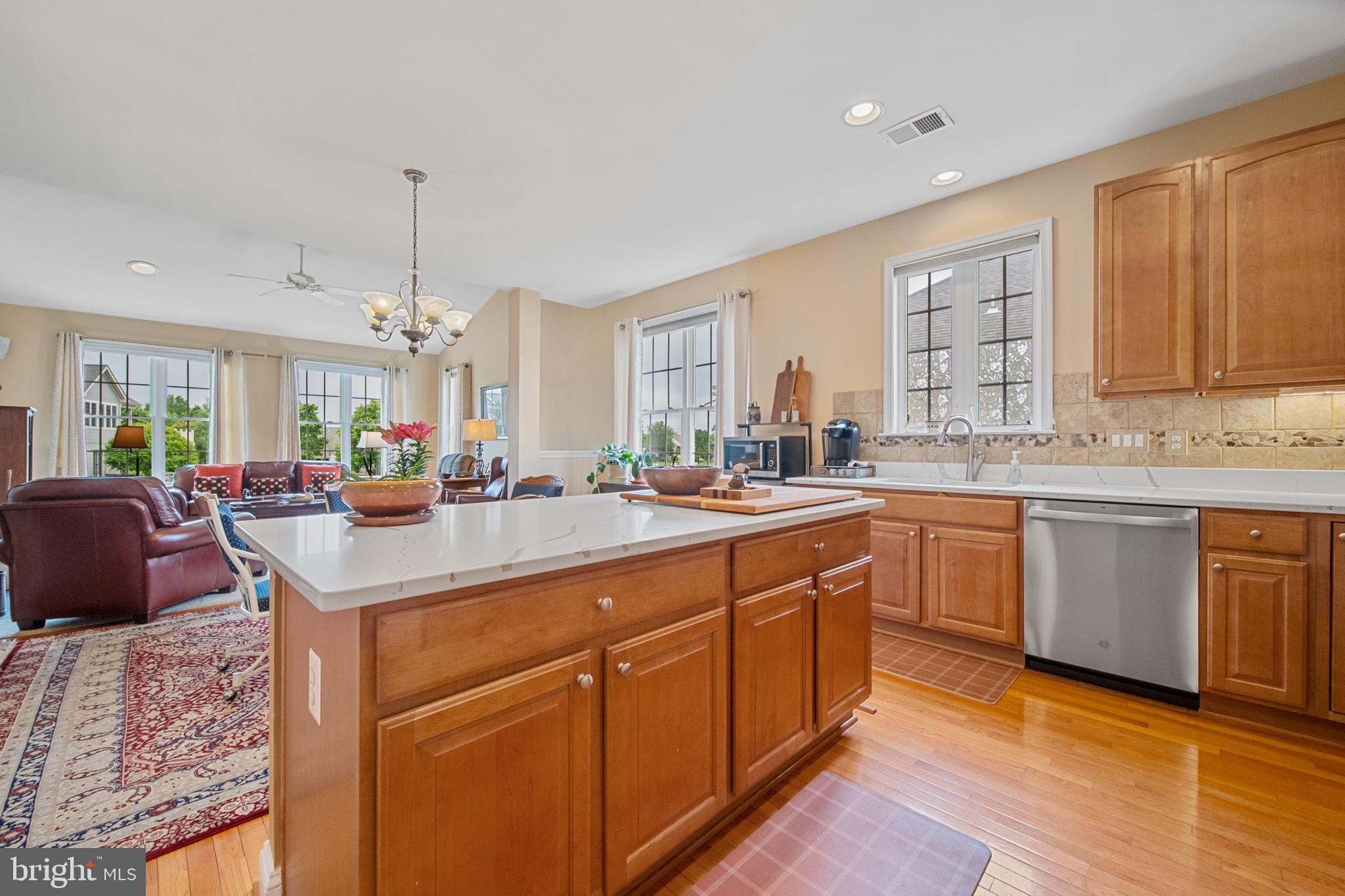 6051 Piney Grove Way Gainesville, VA 20155 - Photo 21 of 64 a large kitchen with kitchen island granite countertop a sink a counter space and stainless steel appliances