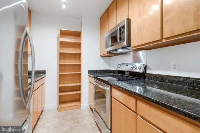 a kitchen with stainless steel appliances granite countertop a stove and a microwave