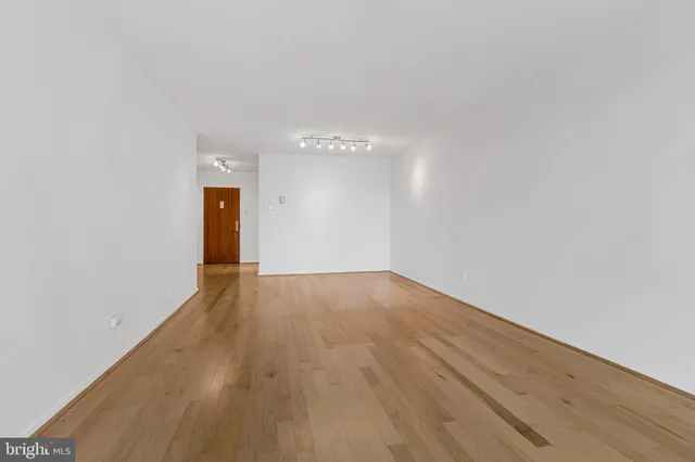 a view of an empty room and wooden floor