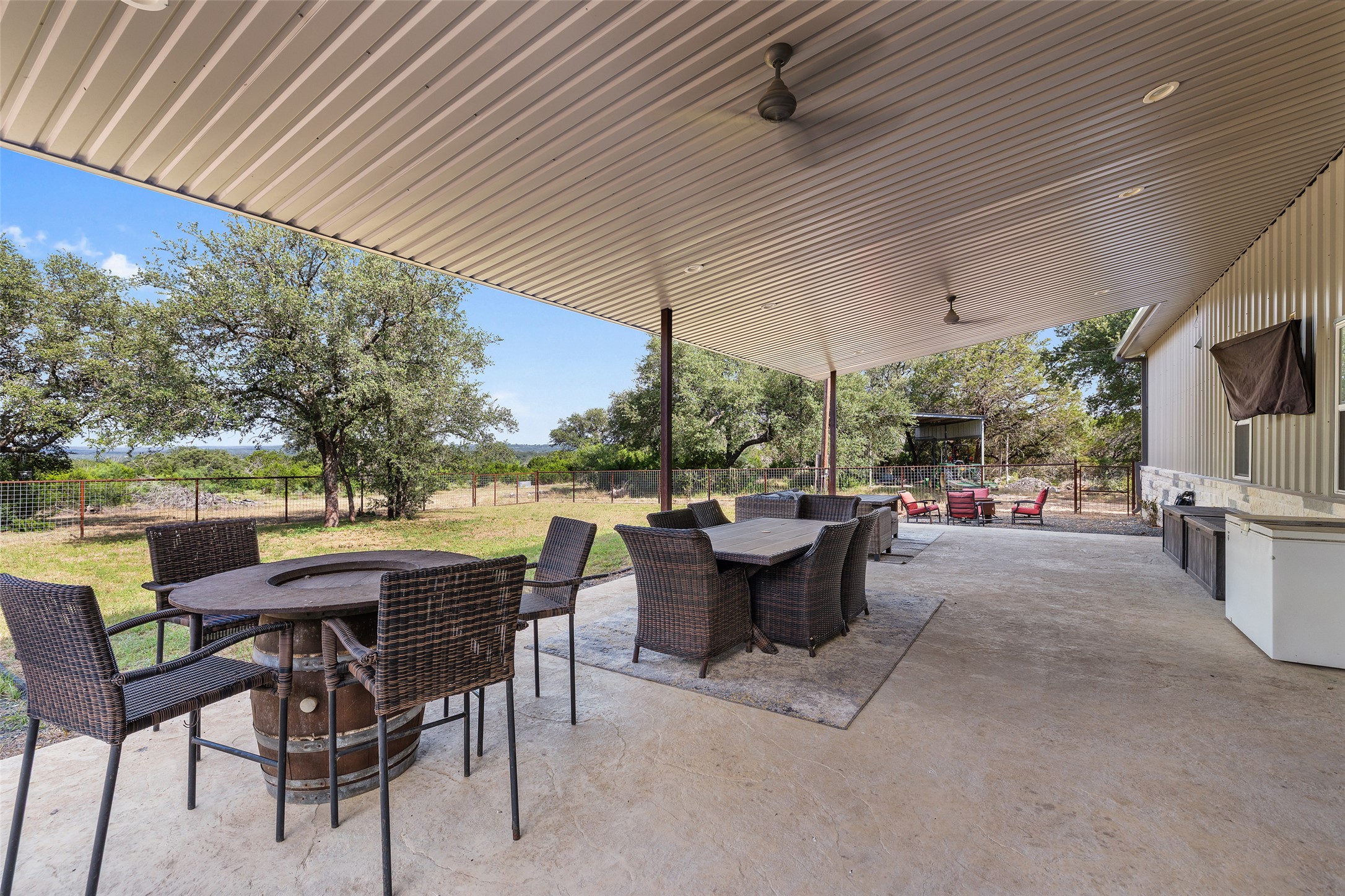 764 Stubbs Road Johnson City, TX 78636 - Photo 3 of 29 An inviting covered patio with a textured concrete surface offers ample space for outdoor dining and entertaining.
