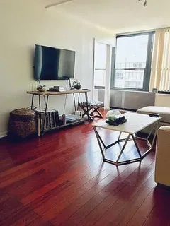 a living room with furniture and a flat screen tv with wooden floor