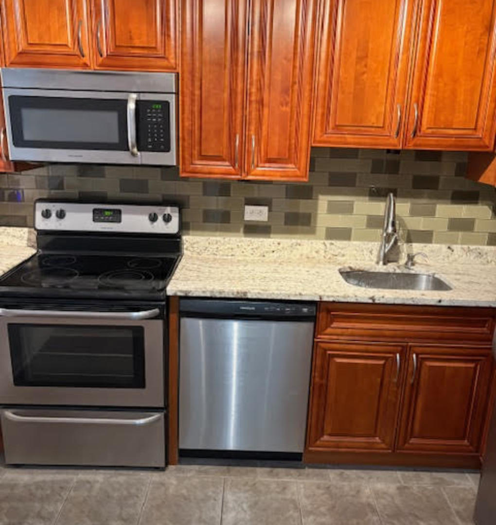 1560 North Sandburg Terrace, Unit 2007 Chicago, IL 60610 - Photo 4 of 25 a kitchen with stainless steel appliances granite countertop a stove and a microwave