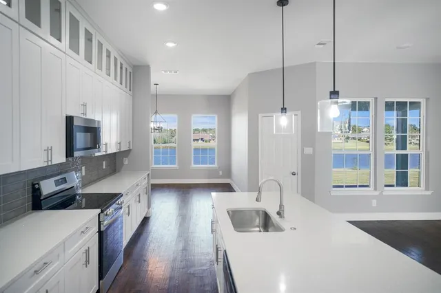 a view of a kitchen with wooden floor and a window