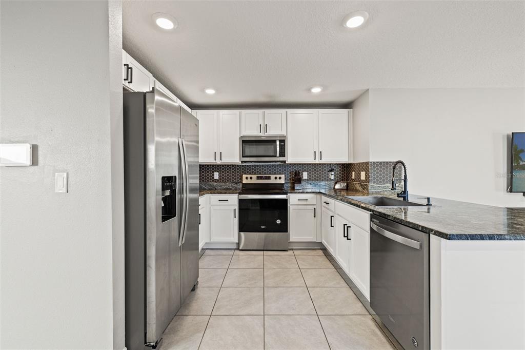 12115 Lily Magnolia Lane Riverview, FL 33569 - Photo 11 of 41 a kitchen with stainless steel appliances granite countertop a refrigerator and a stove top oven