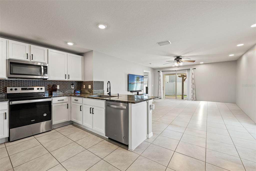 12115 Lily Magnolia Lane Riverview, FL 33569 - Photo 12 of 41 a kitchen with granite countertop a stove top oven and cabinets