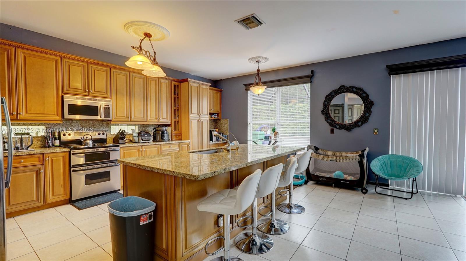 Silver Shores Miramar, FL 33027 - Photo 10 of 30 a large kitchen with stainless steel appliances a stove a table and chairs