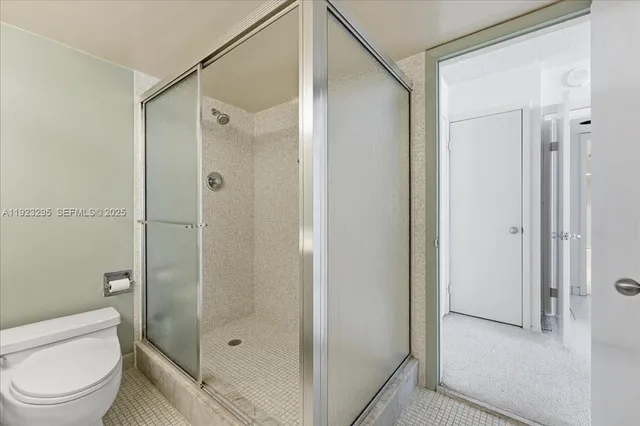 a bathroom with a shower a toilet and sink