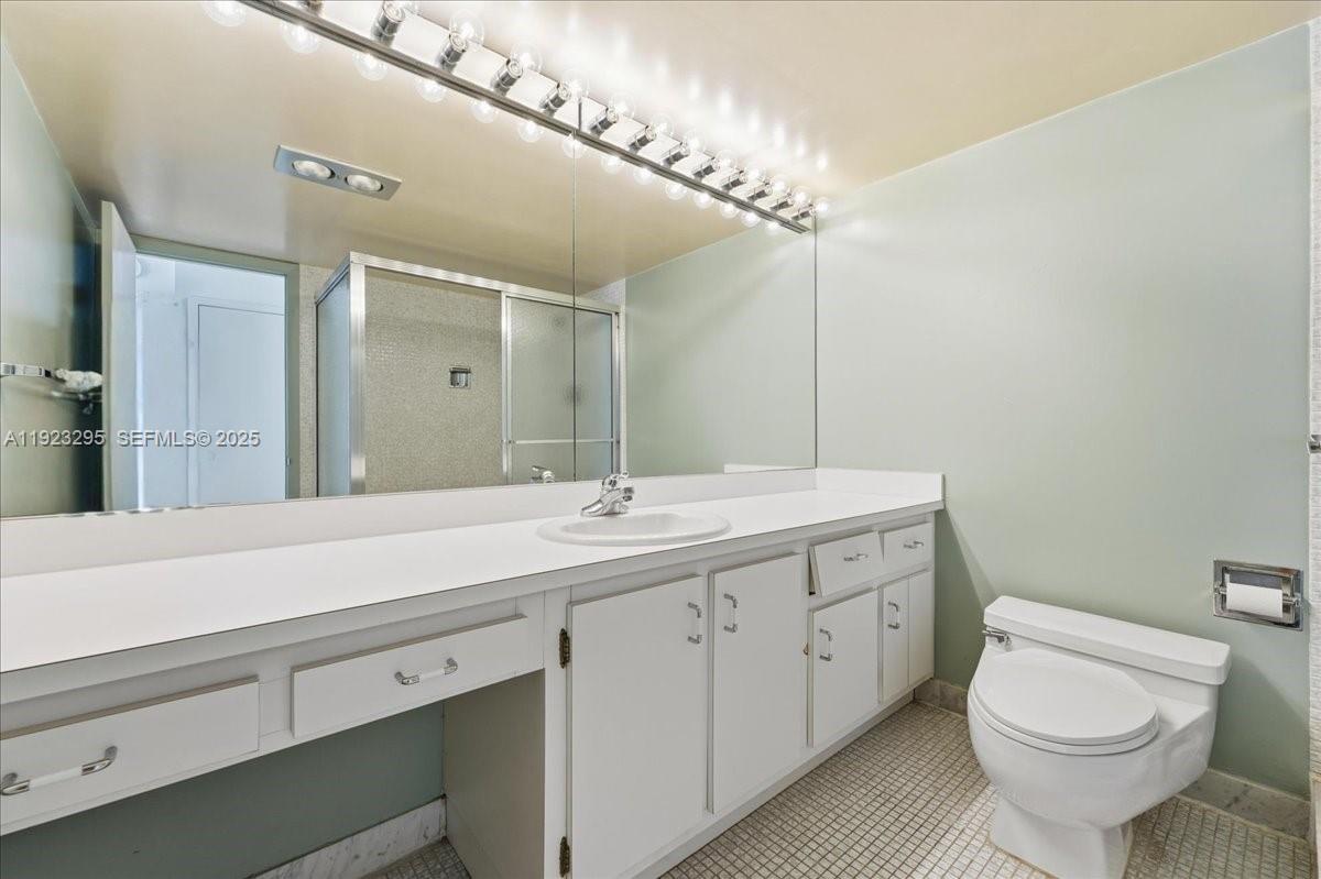 4280 Galt Ocean Drive, Unit 12H Fort Lauderdale, FL 33308 - Photo 19 of 31 a bathroom with a toilet a sink and a mirror