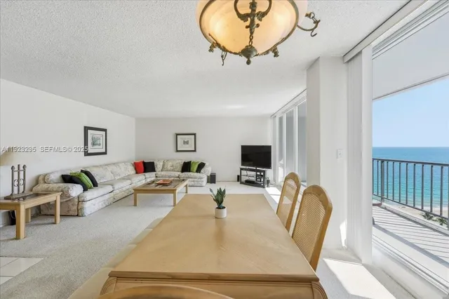 a living room with furniture a flat screen tv and a large window