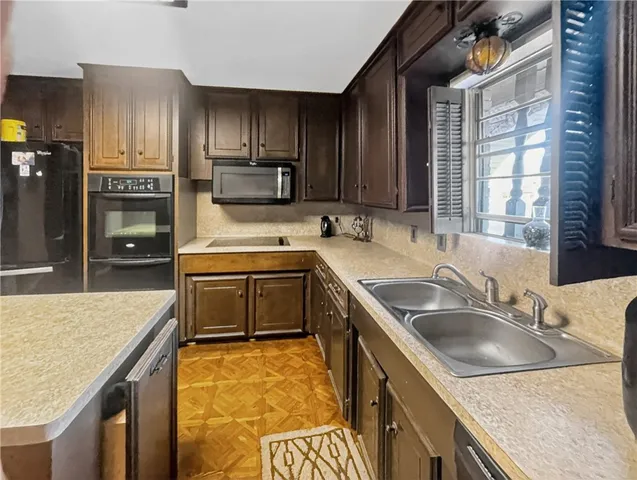 a kitchen with a sink stove top oven and refrigerator