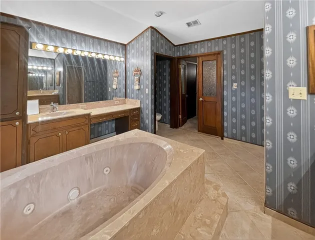 a spacious bathroom with a double vanity sink and a large mirror