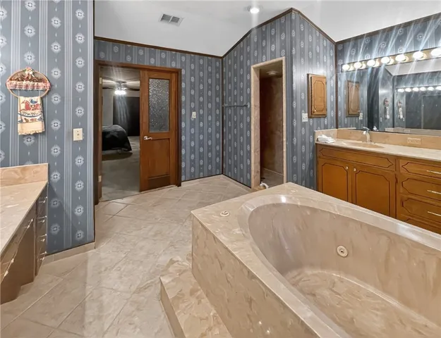 a spacious bathroom with a bathtub sink and mirror