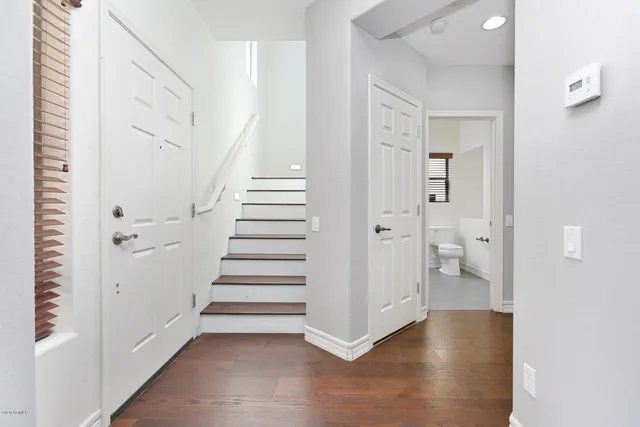 a view of a hallway with wooden floor and staircase