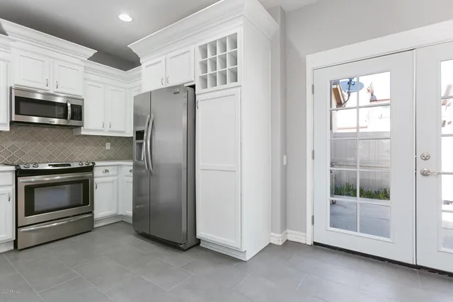 a kitchen with stainless steel appliances white cabinets and a refrigerator